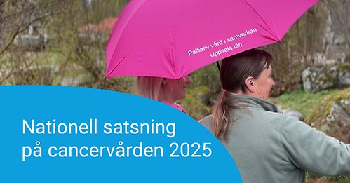 Två damer står under ett paraply och tittar